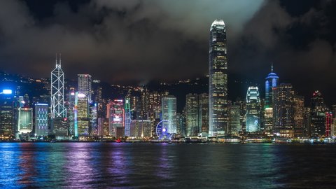 Hong Kong, China, zoom out time lapse view of famous Hong Kong skyline and Victoria Harbour at night. 