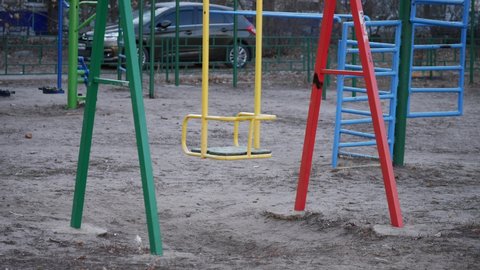 lonely swing swinging in the wind without people in the coronavirus. pandemic stay home pandemic. children playground no people swing covid 19. children swing during the coronavirus period