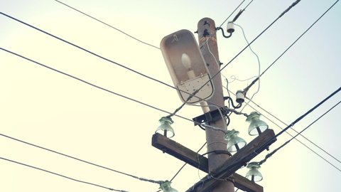 street old lamp with wires and electricity. lamppost for street lighting close-up. lamp in the lantern on the pole. lightning high voltage concept electricity current