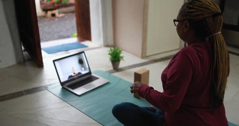 African senior woman doing online yoga lesson at home during coronavirus outbreak 