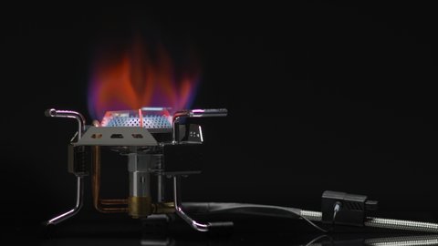 Turn off a gas stove. Bright red flame of Burning Fire and hot Metal on a black background.