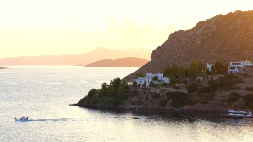 White Aegean houses of Yalikavak next to sea and sunset at Bodrum, Turkey. Bodrum is most popular summer vacation area for tourist in Turkey.  Royalty-Free Stock Footage #1063591996