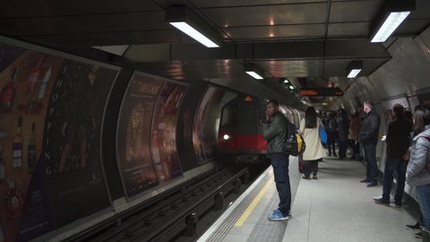 London , England , United Kingdom (UK) - 12 26 2019: London Underground, Train Arriving at Metro Station, People Traveling on Christmas Holidays, Slow Motion