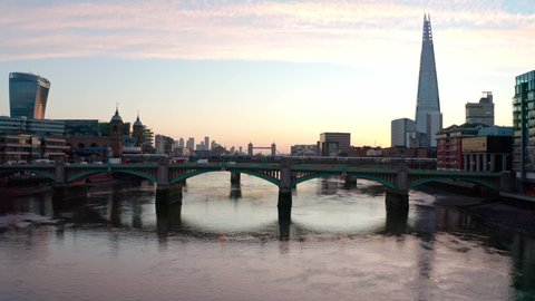Cinematic rising dolly back aerial crane drone shot of sunrise over Thames river and central London
