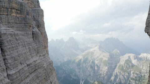 Closeup Aerial of flying in between 2 cliffs in the mountains, Tre cime die Lavaredo, Dolomiti, Italia