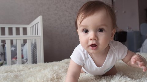 Adorable baby boy crawling on a bed at home