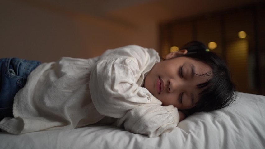 Mother is putting blanket on her little daughter who is sleeping in the bed. love and family care concept. Royalty-Free Stock Footage #1063610059