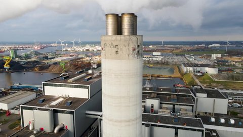 Aerial drone view of a smoking chimney of a waste recovery plant in Amsterdam, The Netherlands. heavy industry close up white smoke and smog