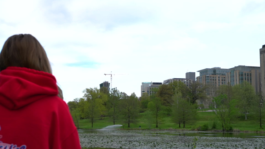 Nice shot of girl overlooking a lake and city at Forest Park in St.Louis, Missouri.