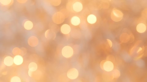 Golden colored bokeh abstract background for New year, Christmas 2021, party, Celebration. Golden Christmas blurred lights festive backdrop. Colorful shimmer glitter with bokeh for overlay, background
