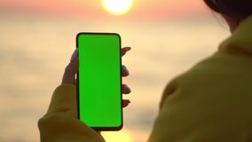 Handheld Camera: Point of View of Woman at beach Using Phone With Green Mock-up Screen Chroma Key Surfing Internet Watching Content Videos Blogs Tapping on Screen