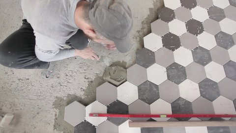 Laying tiles. Tile adhesive. Installing ceramic floor tiles-measuring and laying pieces. Construction, renovation, apartment renovation.