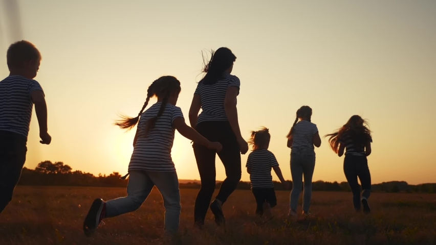 Children happy family kid together run in the park at sunset silhouette. people in the park concept. mom daughter and son joyful run. fun happy family and little baby child summer kid dream concept | Shutterstock HD Video #1063641439