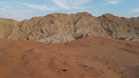 Drone View of Desert Safar, offroading in Sharjah's Mleiha desert, group of 4x4 vehicles rides on desert dunes, Mleiha Mountains, 4k Footage