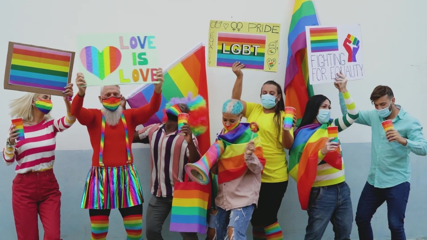 Happy Multiracial people wearing face mask celebrating at gay pride festival during corona virus - Group of friends with different age and race dancing together and fighting for gender equality Royalty-Free Stock Footage #1063649587