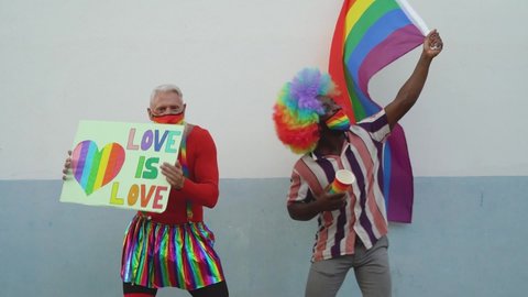 Activist people with different age and ethnicity having fun celebrating gay pride festival dancing and protesting for gender equality - LGBT social movement concept 