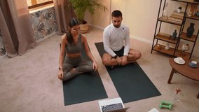 Top View Of Young Happy Caucasian Man And Woman Couple In Sportswear Doing Stretching Exercise With Laptop In Bright Room At Home. Stay Home Quarantine Workout Concept Of Sport Relax And Meditation