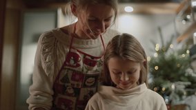 Close-up hands view. Mom and daughter are preparing cookies for the New Year and Christmas in the kitchen. Mom help daughter cutting out cookies in the shape of a Christmas tree, bear and snowman. - Powered by Shutterstock - Get 15% off with code: PIKWIZARD15