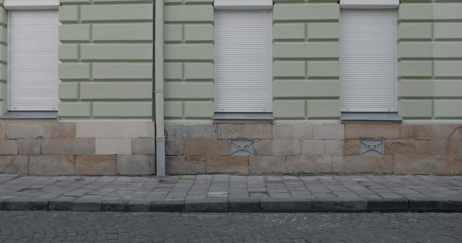 Side view of teenager boy dribbling at empty old city street. Talanted kid running and kicking football ball. Concept of lifestyle, childhood, sport.