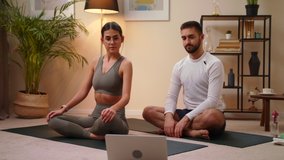 Young Happy Caucasian Man And Woman Couple In Sportswear Doing Stretching Exercise At Home On Mat While Watching Fitness Video Online On Laptop. Stay Home Quarantine Workout Concept Of Sport Relax.