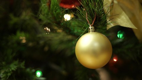 Golden Christmas Ball. Christmas tree. Bright and colored lights. Decorated Tree.  Bokeh lights.