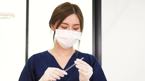 Beautician Woman, asian doctor or nurse, beauty specialist with face mask in beauty clinic prepare cosmetic treatment injection with Syringe. Woman in beauty salon. Cosmetological clinic. Healthcare.