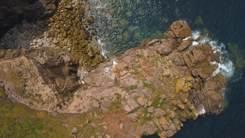 Aerial: beautiful rocky Cornwall coastline, UK, top down view