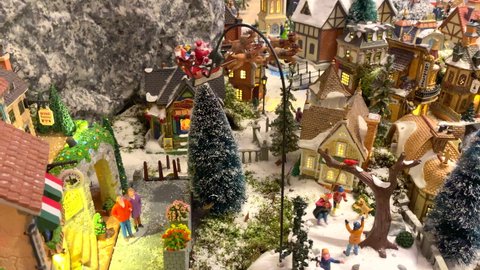 Christmas miniature village with miniature mini dolls and flying Santa Sleigh with reindeer