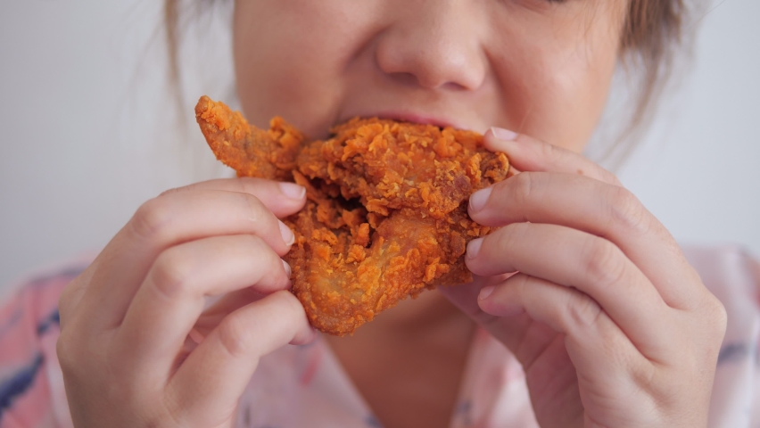 Close up shot of fat woman eating deep fried chicken, fast food. Enjoying unhealthy eating - junk food concept. Close up mouth eating. Royalty-Free Stock Footage #1063680331