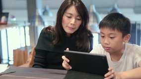 Mom teaches children to use taplet for online learning education class study video call at home