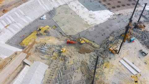 Construction of a stadium, exhibition complex, arena. Heavy machines for driving pillars work in laying the foundation building. Aerial view height
