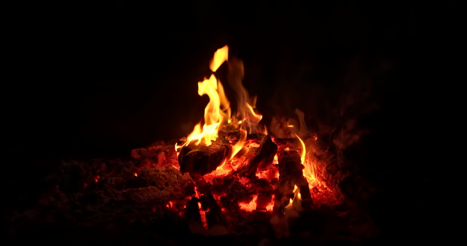 Close-up, flames from fire. Night bonfire, logs are on fire, sparks fly. 4k, ProRes