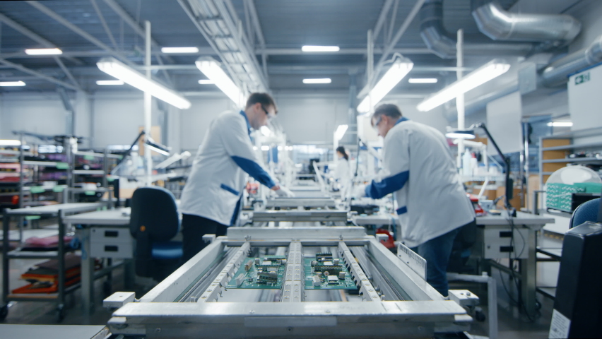 Modern High-Tech Electronics Factory Moving Manufacturing Conveyor: Professionals Doing Precision Work Assemble Circuit Boards, Processors, Microchips, Semiconductors. High-Quality Production Line | Shutterstock HD Video #1063689862