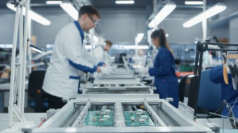 Modern High-Tech Electronics Factory Moving Manufacturing Conveyor: Professionals Doing Precision Work Assemble Circuit Boards, Processors, Microchips, Semiconductors. High-Quality Production Line