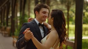 Closeup charming man and woman having first dance outdoors. Portrait of happy wedding couple dancing in garden. Cute bride and groom having fun on wedding ceremony. - Powered by Shutterstock - Get 15% off with code: PIKWIZARD15