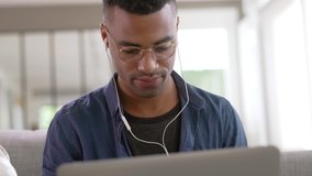 mixed-raced young man working from home on laptop