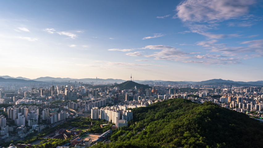 Zoom in, Time lapse 4K Seoul city skyline and Seoul tower modern building and architecture, Beautiful clouds flow through in Seoul, South Korea.