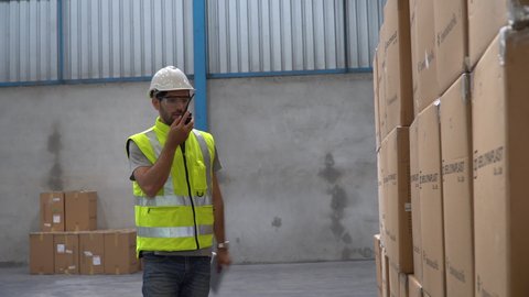 Angry supervisor Detect found mistake in the warehouse blamed worker and walk away . frustrated staff used walkie talkie to blame employees in charge of the workspace in factory