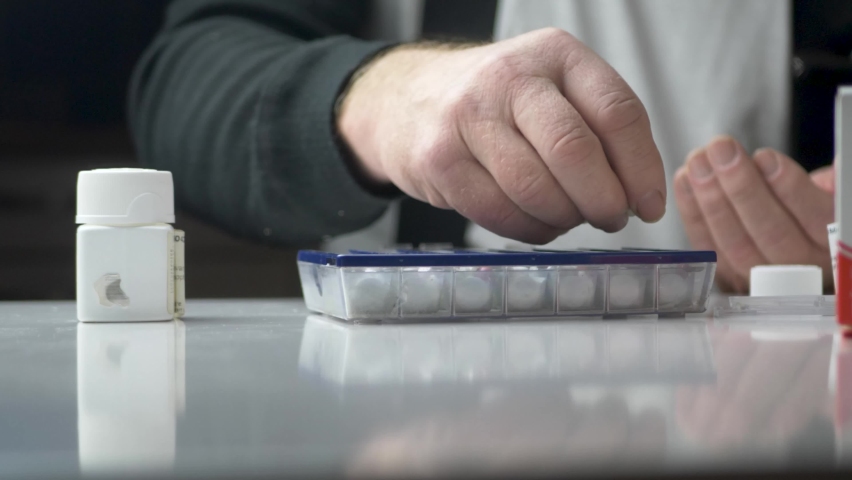 Old man dividing his weekly pills by the Medicine pill case - Static close up shot Royalty-Free Stock Footage #1063712218