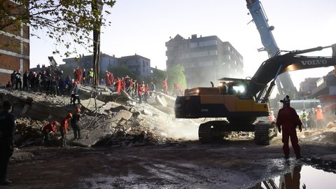 Rescue teams and excavator searching through the buildings destroyed during the earthquake in Izmir, Turkey, Monday, Nov. 2, 2020.