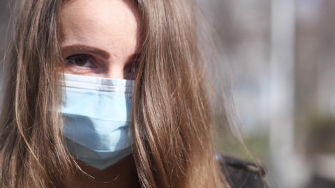 Close Up Portrait of a Young Woman With Face Mask Walking and Looking at Camera. Cinematic Slow Motion