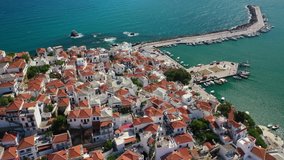 Aerial drone video of beautiful main town and port of Skopelos island featuring uphill Venetian castle and church of Virgin Mary, Sporades islands, Greece