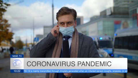 Handsome Young Man Journalist In Protective Mask Suit And Tie Presenting Breaking News TV About Coronavirus Pandemic On Street Outdoors Cars On Signals Police In Background Pandemic City Slow Mo