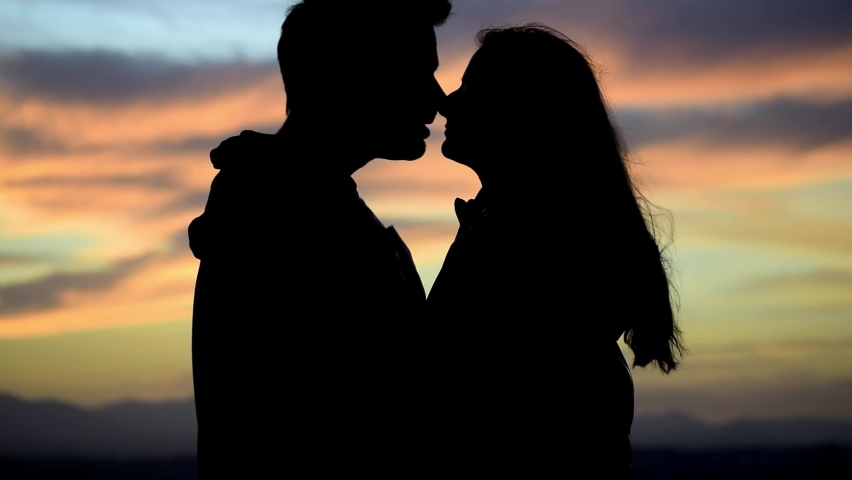 Silhouette of kissing couple against sunset at mountain top. Romantic scene of lovers kiss. Romance and activities for in love people in Saint Valentine's Day, Spain.. | Shutterstock HD Video #1063731619