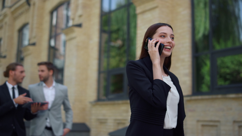 Business woman speaking mobile phone onthe go to office outdoors. Smiling business people using digital devices while walking on city street. Corporate people rushing to work outside. Royalty-Free Stock Footage #1063735822