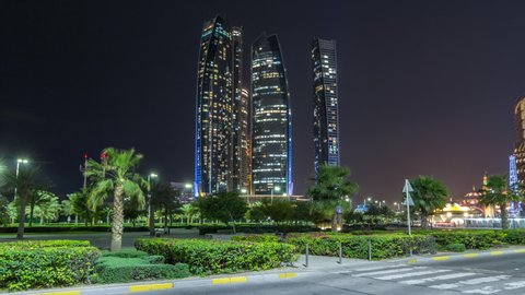 Skyscrapers of Abu Dhabi illuminated at night with towers buildings timelapse hyperlapse. Abu Dhabi is the capital and the second most populous city of the United Arab Emirates