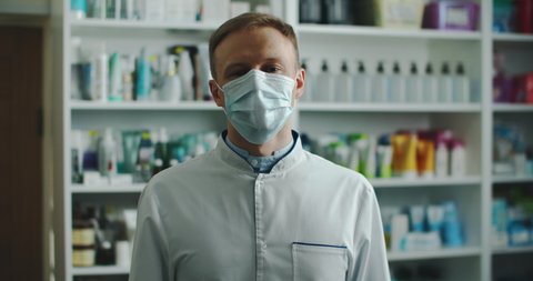 Pharmacist man in a medical mask tells different facts. Male portrait close up. High quality 4k footage