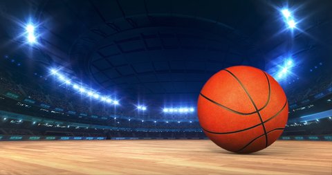 Modern Basketball Arena with shining lights and ball motion on the wooden court. Professional sport 4k video background edited as seamless loop.