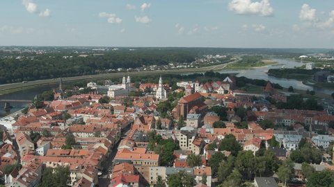 Beautiful skyline of Kaunas city old town with church towers and city hall with Nemunas and Neris rivers confluenceand forest in the background, Aerial drone view.