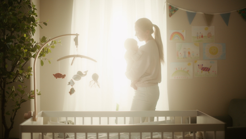 Happy Mother Bonding and Holding a Cute Newborn Baby in Cozy Warm Kids Bedroom. Caring Mom Puts Neonate Toddler Back in the Crib at Home. Concept of Childhood, New Life, Parenthood. Royalty-Free Stock Footage #1063762831